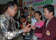 Ifni Djuraidi saat menyerahkan Piala Bupati Kukar kepada pimpinan kontingen kota Tarakan yang sukses meraih gelar Juara Umum Kejurprov Catur Percasi Kaltim 2006 di Tenggarong
