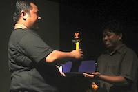 Ketua Yayasan Lanjong menerima trofi dari Indra Hidayat yang menyabet gelar Aktor Terbaik Invitasi Teater Nasional 2012