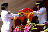 Bupati Rita Widyasari menyerahkan bendera kepada siswi SMAN 1 Seblu, Ropika Sari, untuk dikibarkan
