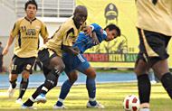 Gelandang Mitra Kukar Mbom Mbom Julien (tengah) berebut bola dengan salah seorang pemain PSAP