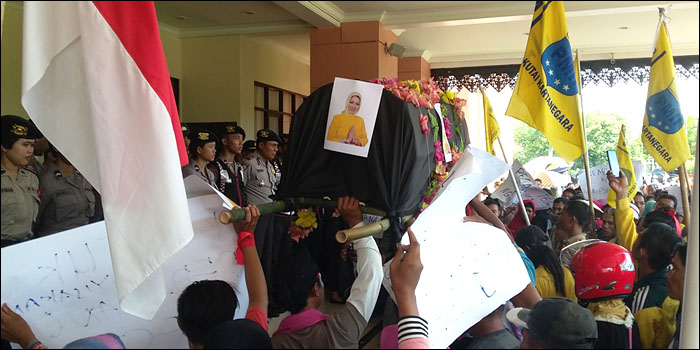 Pedagang membawa keranda dengan foto Bupati Kukar Rita Widyasari saat berunjukrasa di DPRD Kukar, Tenggarong, Senin (23/05) pagi