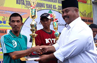 Plt Bupati Kukar Edi Damansyah menyerahkan trofi Juara I Kelas 6 PK kepada Jaini Gani asal Muara Muntai