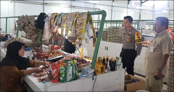 Kepala Disperindag Kukar H Surip dan Tim Satgas Pangan Polres Kukar AKP Damus Asa saat menyambangi salah seorang pedagang Pasar Mangkurawang, Tenggarong