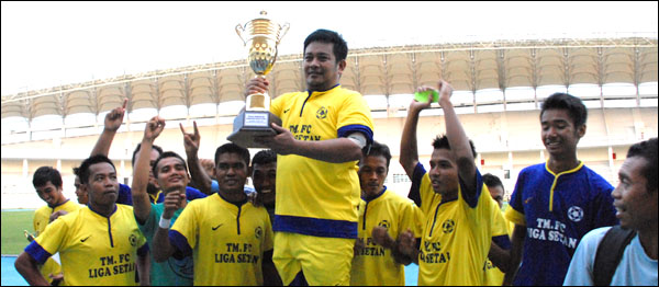 Kapten Tim Tambak Malang FC Roni Fauzan dengan bangga mengangkat trofi bergilir PSSI Kukar sebagai juara Divisi Utama tahun 2013