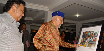 Sultan HAM Salehoeddin II mengamati foto KutaiKartanegara.com yang menyabet gelar Juara II Lomba Foto Erau 2010 kategori Jurnalis