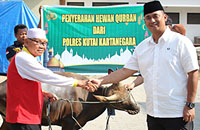 Kapolres Kukar AKBP Anwar Haidar (kanan) menyerahkan sapi kurban kepada perwakilan pengurus masjid di Tenggarong