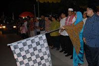 Bupati Rita Widyasari memegang bendera <i>start</i> untuk melepas keberangkatan peserta pawai takbir keliling kota Tenggarong