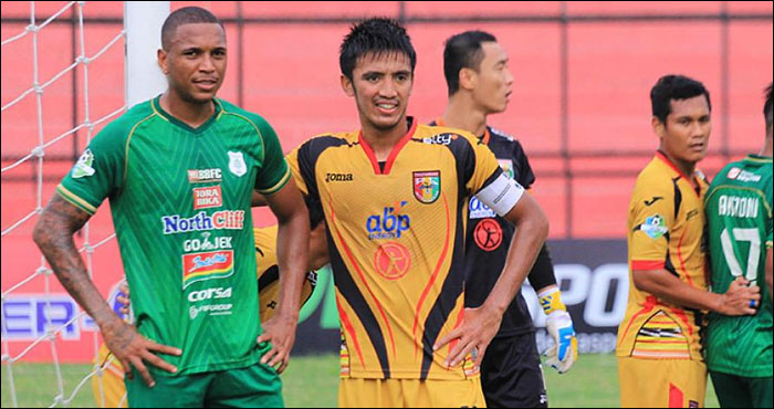 Kapten tim Bayu Pradana (tengah) mengawal ketat striker PSMS Felipe Martins