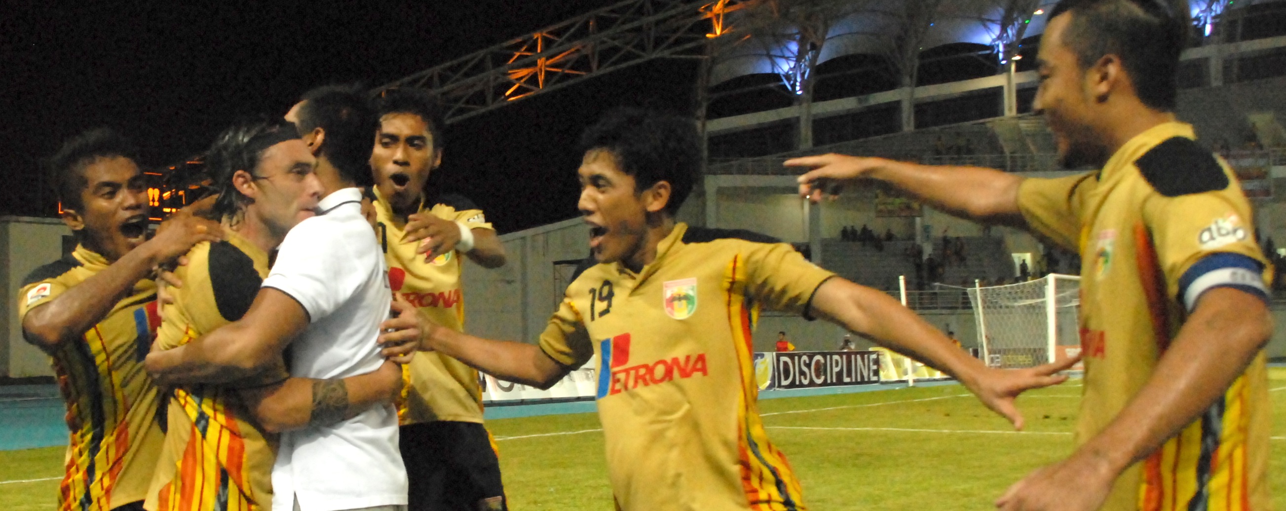 Para pemain Mitra Kukar mengerumuni Esteban Herrera yang sukses melakukan eksekusi penalti penentu kemenangan Mitra Kukar atas Pelita Bandung Raya