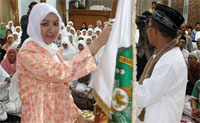 Bupati Kukar Rita Widyasri menyerahkan bendera berlambang Kabupaten Kukar kepada pimpinan kloter jamaah calhaj Kukar H Darmansyah