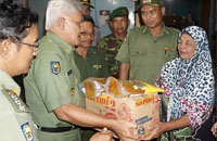 Pj Bupati Kukar Chairil Anwar menyerahkan bantuan secara simbolis kepada nek Nio