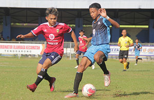 Duel perebutan bola antara pemain Muara Kaman (merah) dan Kembang Janggut (biru) 