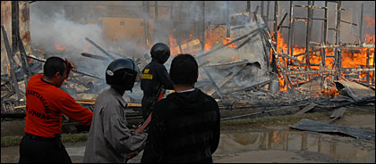 Petugas PMK bersama masyarakat berupaya memadamkan api yang masih berkobar