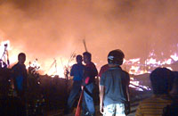 Petugas PMK dan masyarakat berupaya memadamkan api yang masih berkobar di Jalan Kartini