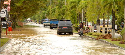 Situasi di Jalan Pesut yang terendam banjir. Warga sekitar terpaksa menjebol median jalan untuk menyalurkan genangan air