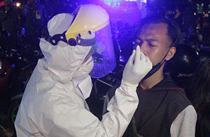 Petugas melakukan tes swab antigen terhadap salah seorang pengunjung angkringan di lapangan parkir Stadion Rondong Demang