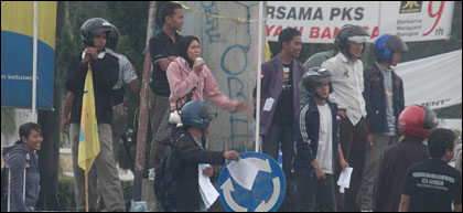 Para pengunjukrasa melakukan aksi di tengah guyuran hujan gerimis