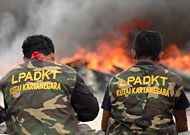 Dua anggota LPADKT Kukar duduk menyaksikan kobaran api didepan pintu gerbang Kantor Bupati Kukar
