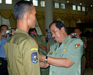Bupati Kukar H Syaukani HR saat menyematkan secara simbolis tanda peserta pelatihan kepada salah seorang anggota Satpol PP Kukar