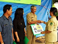 Camat Hj Rusmina SH MAP saat menyerahkan secara simbolis hadiah Juara I kepada Plt Kades Tanah Datar Lodwykos JP
