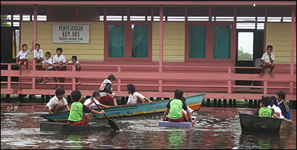 Halaman SDN 003 Muara Kaman Ilir yang terendam banjir menjadi arena bermain perahu bagi siswa sekolah tersebut