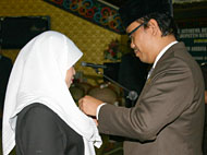Ketua DPRD Rahmat Santoso menyematkan pin lambang daerah Kukar kepada Aini Farida