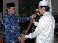 Asisten III AR Ruzni Oms (kiri) menyerahkan bendera kepada Kepala Kandepag Kukar H Djamaluddin HD selaku Wakil Pimpinan Kafilah MTQ Kukar