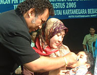 Assisten II Pemkab Kukar Dr HARM Haryanto Bachroel MM tengah memberikan imunisasi vaksin polio kepada balita pada pencanangan PIN tahap I di Kukar
