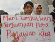 Salah seorang kader PMII membawa poster berisi ajakan untuk meneruskan perjuangan pahlawan