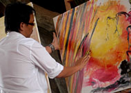 Rachmat Santoso melukis di atas kanvas dengan menggunakan jari-jari