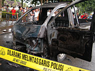 Petugas Polres Kukar langsung membentangkan garis polisi setelah kobaran api yang membakar mobil berhasil dipadamkan